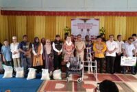 Bupati Natuna Cen Sui Lan berfoto bersama penerima bantuan sosial, perangkat daerah, dan tokoh masyarakat Midai usai penyerahan paket sembako, alat bantu disabilitas, dan santunan program ketenagakerjaan. Foto: INIKEPRI.COM