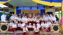Bupati Natuna Cen Sui Lan berfoto bersama para siswa SD di Kecamatan Midai usai menyerahkan bantuan perlengkapan belajar pada kunjungan kerjanya. Foto: Istimewa 