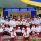 Bupati Natuna Cen Sui Lan berfoto bersama para siswa SD di Kecamatan Midai usai menyerahkan bantuan perlengkapan belajar pada kunjungan kerjanya. Foto: Istimewa 