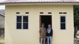 Emat, 77 tahun, bersama putrinya di depan rumah yang dibangun Pemerintah Provinsi Kepri melalui Dinas Perkim di Toapaya Selatan, Kecamatan Toapaya, Kabupaten Bintan. Foto: INIKEPRI.COM/KepriProv 