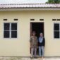 Emat, 77 tahun, bersama putrinya di depan rumah yang dibangun Pemerintah Provinsi Kepri melalui Dinas Perkim di Toapaya Selatan, Kecamatan Toapaya, Kabupaten Bintan. Foto: INIKEPRI.COM/KepriProv 