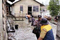 personel Satuan Pembinaan Masyarakat (Satbinmas) Polres Lingga bergerak cepat melakukan evakuasi terhadap warga terdampak. Foto: INIKEPRI.COM