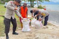 Wakapolres Lingga, KOMPOL Darmin, S.Sos., memimpin langsung kegiatan gotong royong pembangunan tanggul darurat untuk menahan laju abrasi di Jalan Pesisir Desa Lanjut, Kecamatan Singkep Pesisir, Kabupaten Lingga, Rabu (10/12/2025). Foto: INIKEPRI.COM