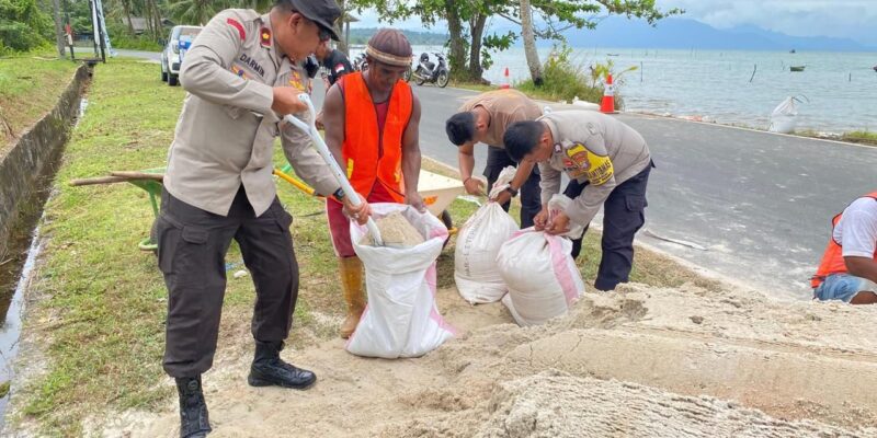 Wakapolres Lingga, KOMPOL Darmin, S.Sos., memimpin langsung kegiatan gotong royong pembangunan tanggul darurat untuk menahan laju abrasi di Jalan Pesisir Desa Lanjut, Kecamatan Singkep Pesisir, Kabupaten Lingga, Rabu (10/12/2025). Foto: INIKEPRI.COM