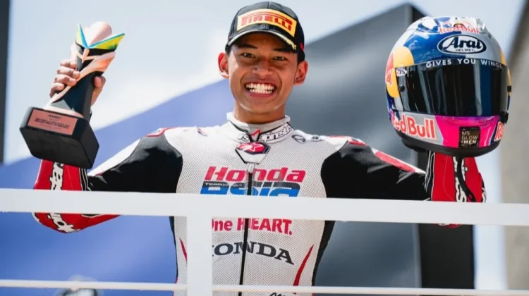 Pembalap asal Indonesia, Veda Ega Pratama memegang trofi dan helmya di podium Moto3 Brasil, Minggu, 22 Maret 2026. Foto: Instagram/veda_54
