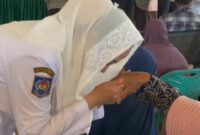 Bupati Natuna Cen Sui Lan mencium tangan seorang lansia. Foto: INIKEPRI.COM