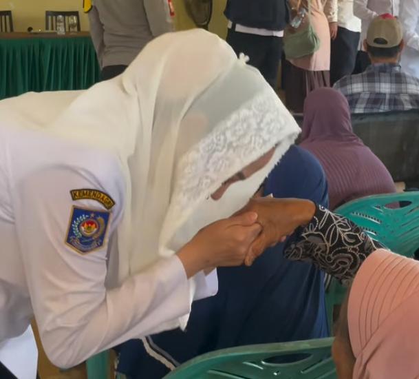 Bupati Natuna Cen Sui Lan mencium tangan seorang lansia. Foto: INIKEPRI.COM