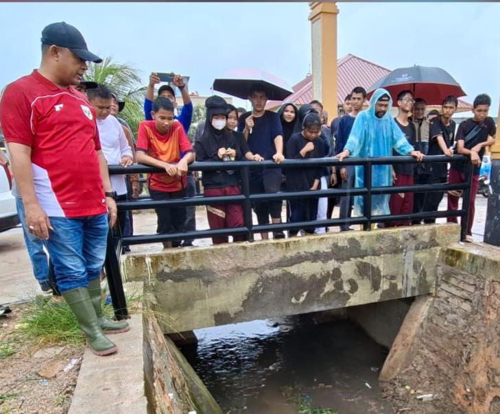 Ketua DPRD Kepri Iman Sutiawan menyusuri saluran drainase di RW 10, Kelurahan Tiban Indah, Kecamatan Sekupang. Foto: INIKEPRI.COM
