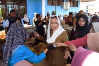 Bupati Natuna Cen Sui Lan turun langsung melayani warga yang berbelanja di Pasar Pangan Murah di Kelarik, Kecamatan Bunguran Timur. Foto: Sar/acikepri.com