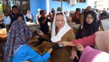 Bupati Natuna Cen Sui Lan turun langsung melayani warga yang berbelanja di Pasar Pangan Murah di Kelarik, Kecamatan Bunguran Timur. Foto: Sar/acikepri.com