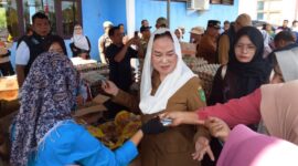 Bupati Natuna Cen Sui Lan turun langsung melayani warga yang berbelanja di Pasar Pangan Murah di Kelarik, Kecamatan Bunguran Timur. Foto: Sar/acikepri.com