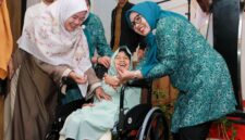 Ketua TP-PKK Batam, Erlita Amsakar, menyerahkan kursi roda kepada salah seorang penerima. Foto: INIKEPRI.COM