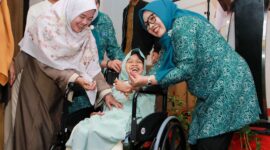Ketua TP-PKK Batam, Erlita Amsakar, menyerahkan kursi roda kepada salah seorang penerima. Foto: INIKEPRI.COM
