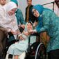 Ketua TP-PKK Batam, Erlita Amsakar, menyerahkan kursi roda kepada salah seorang penerima. Foto: INIKEPRI.COM