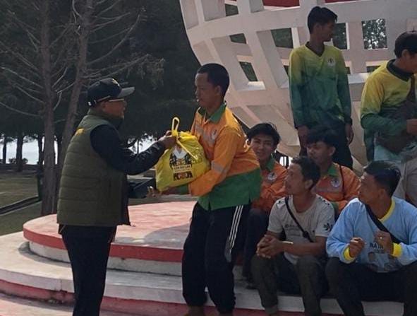 Raja Mustakim menyerahkan bantuan sembako ke salah satu petugas kebersihan. Foto: INIKEPRI.COM